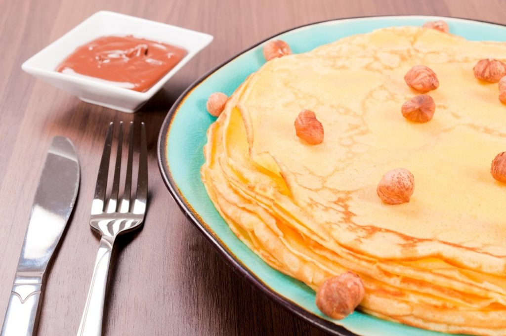 Clatite de post pe farfurie cu alune si crema de alune langa